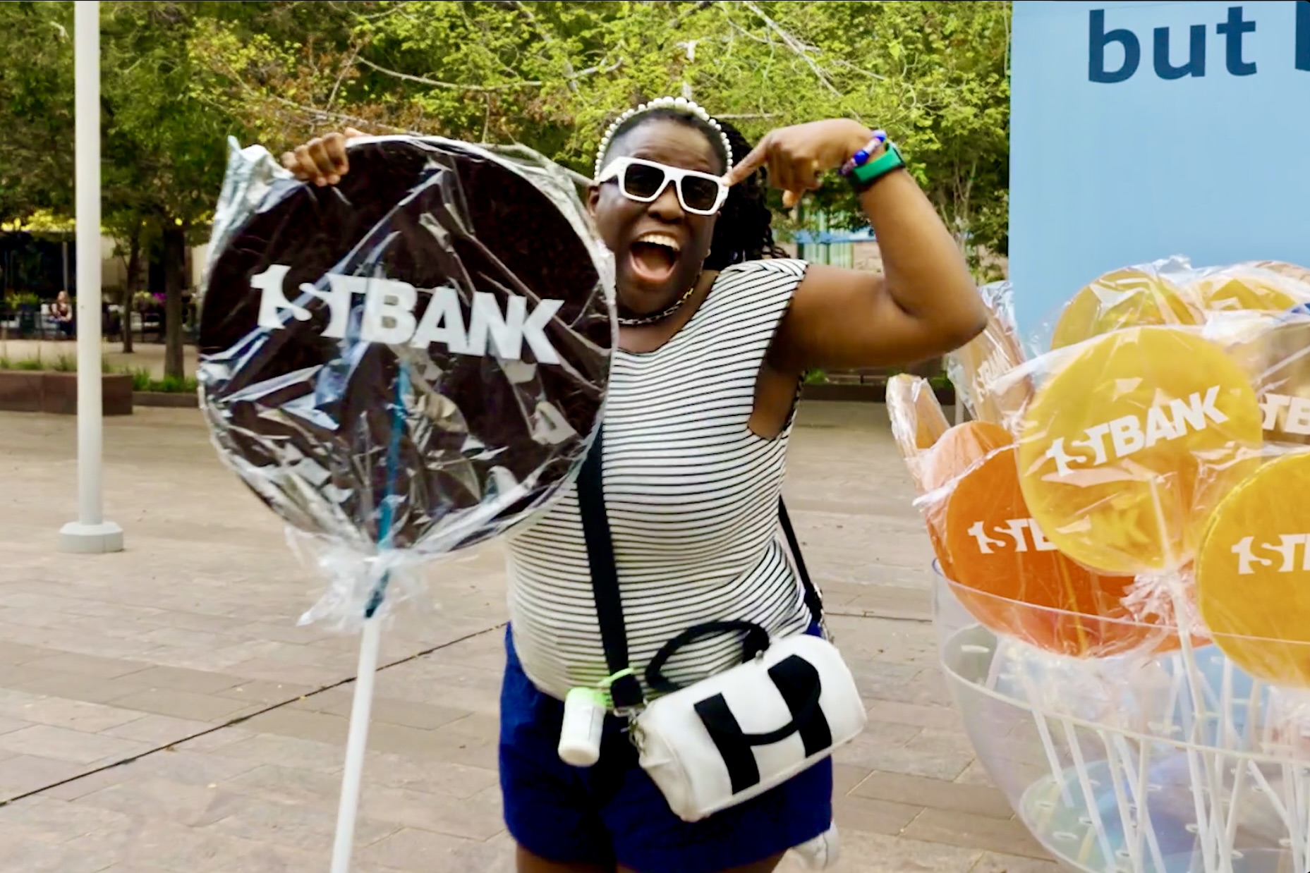 Guest smiling with an oversized black First Bank branded lollipop.